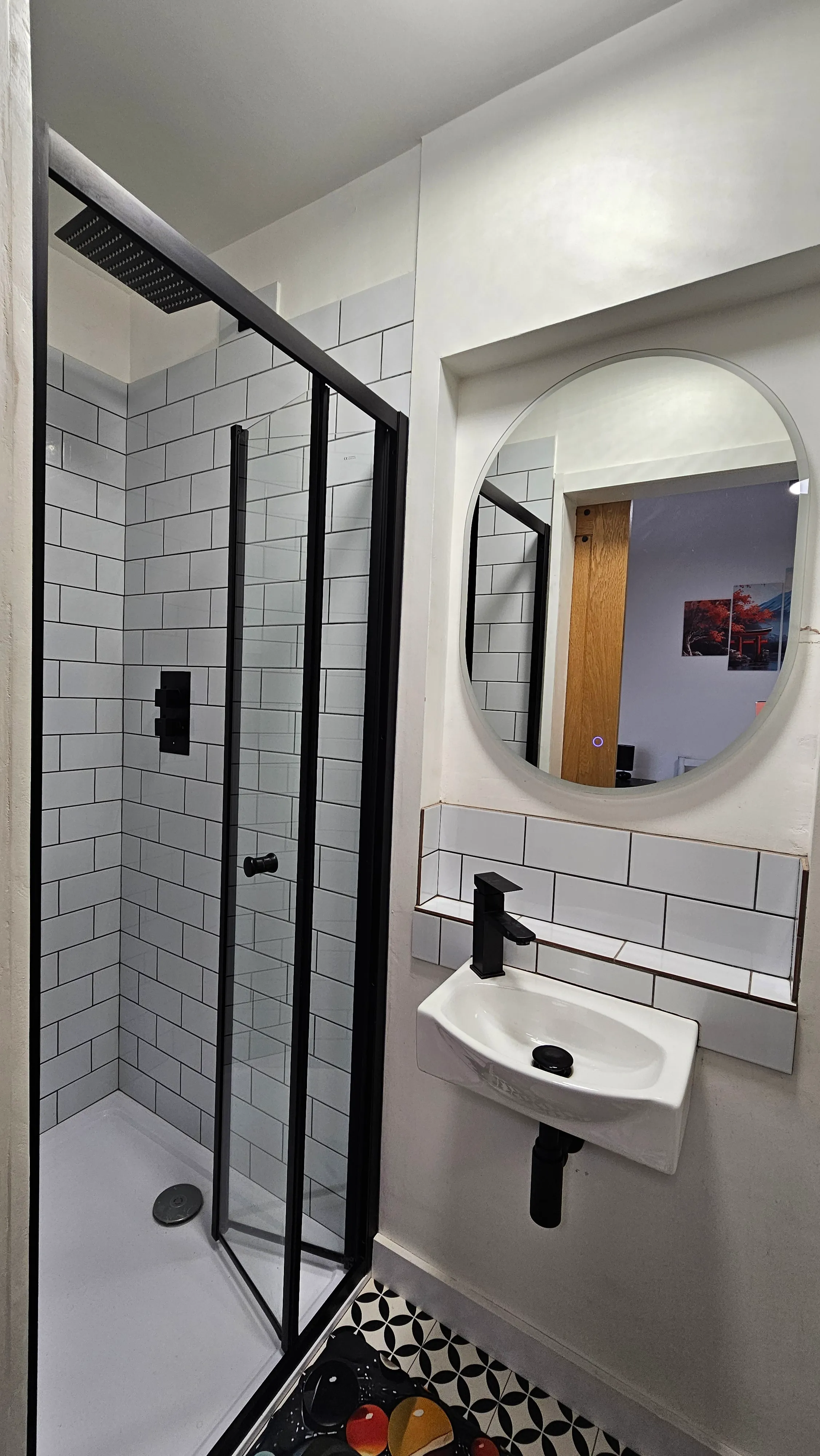 Shower completed - black framed glass enclosure with metro tile and modern fixtures