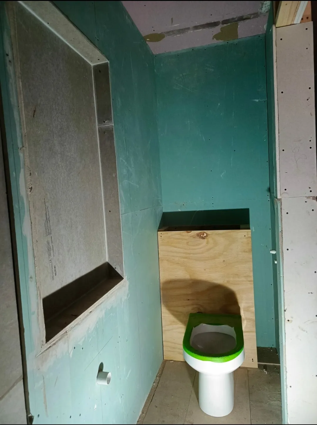 Bathroom before renovation - early construction with moisture barriers and rough-in work