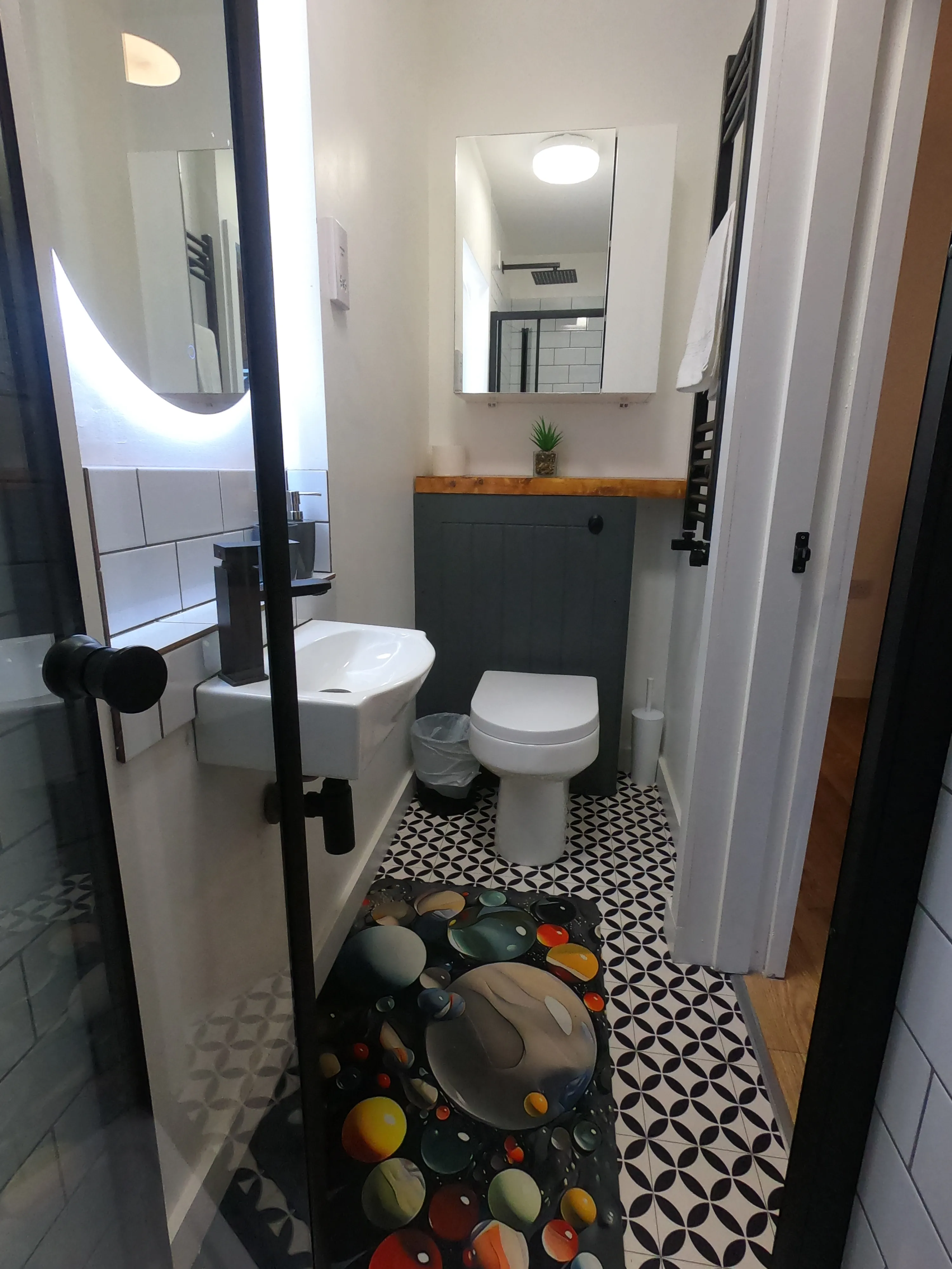 Bathroom completed - modern design with curved mirror, double vanity, and geometric floor tiles