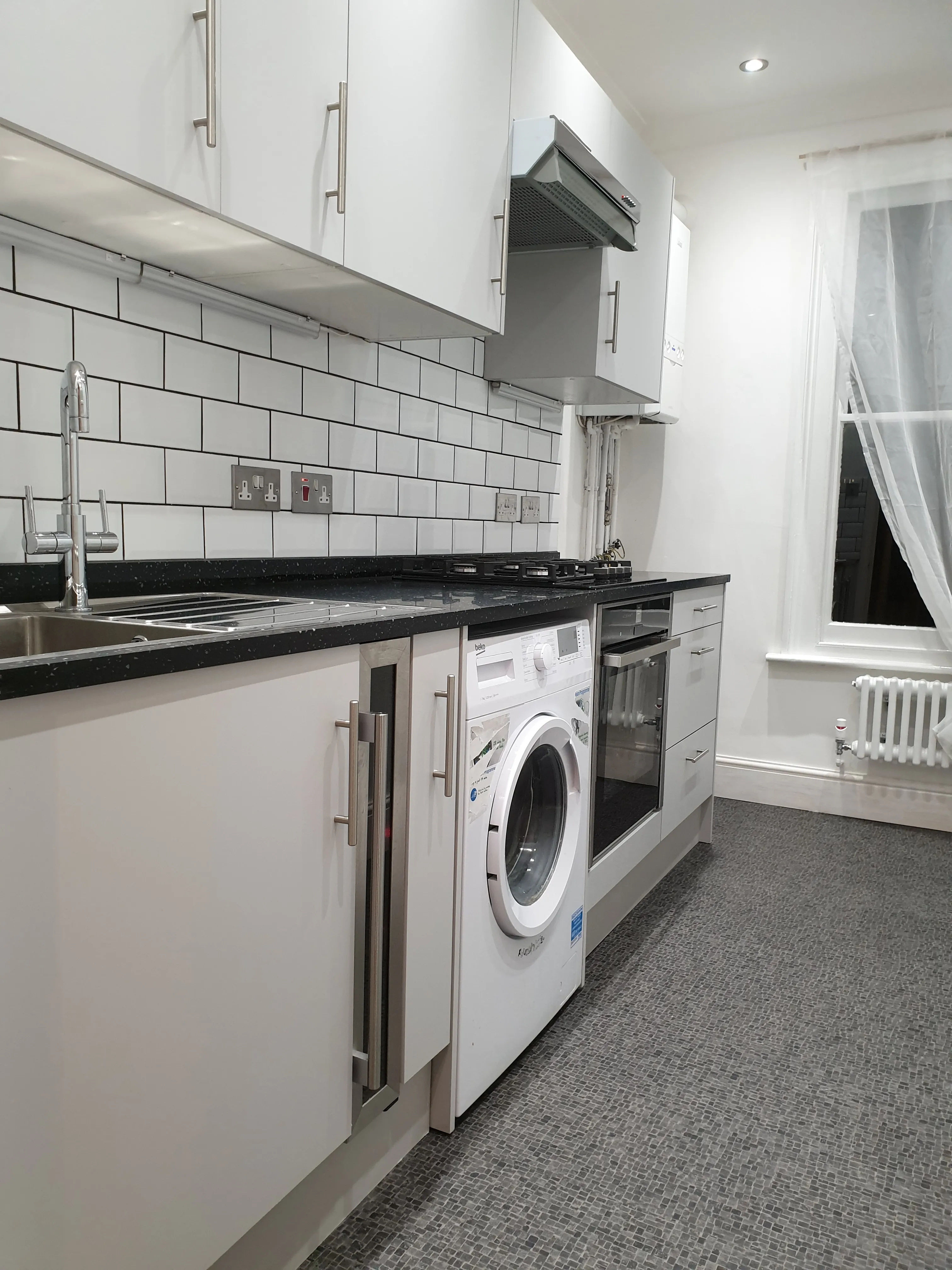 Kitchen completed - modern design with black countertops and subway tile
